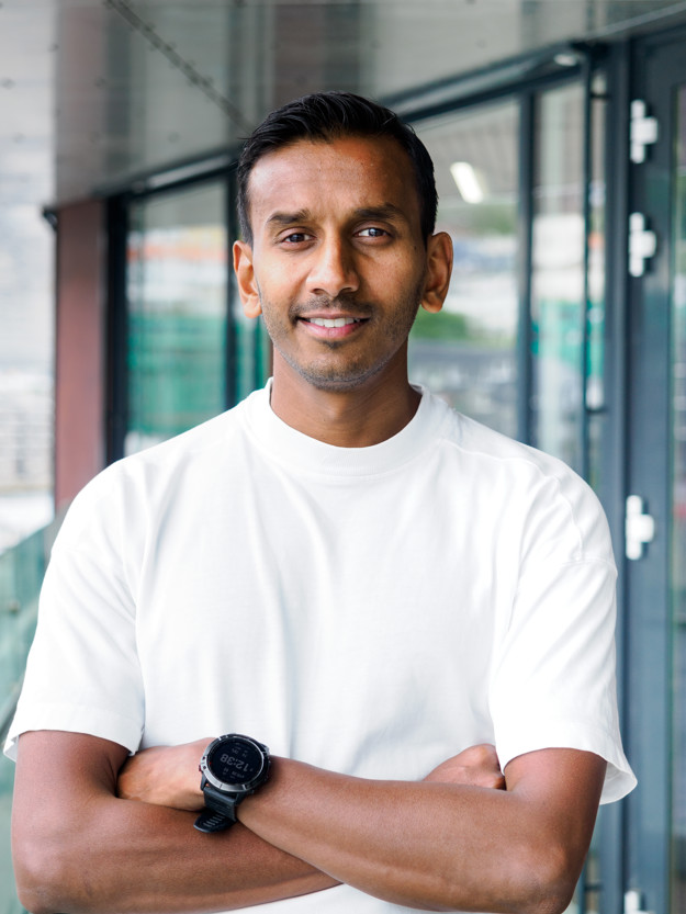 A young man with folded arms and a white t-shirt